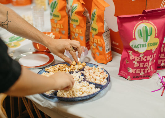 Team members sharing Cactus Corn popcorn and branded bags at a company event