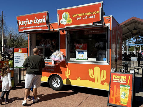 A family walking up to the Cactus Corn kettle corn trailer at an Arizona event
