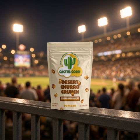 Desert Churro Crunch popcorn bag from Cactus Corn on a stadium railing during a night ballgame