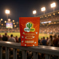 Original Kettle Corn popcorn bag from Cactus Corn on a stadium railing during a night ballgame