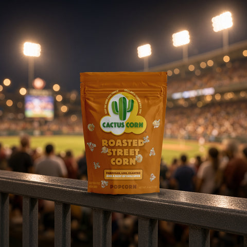 Roasted Street Corn popcorn bag from Cactus Corn on a stadium railing during a night ballgame